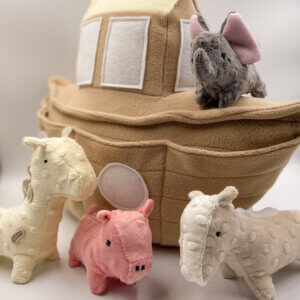 Plush light brown boat with a mini giraffe plush, mini pig plush, mini elephant plush, and mini horse plush.
